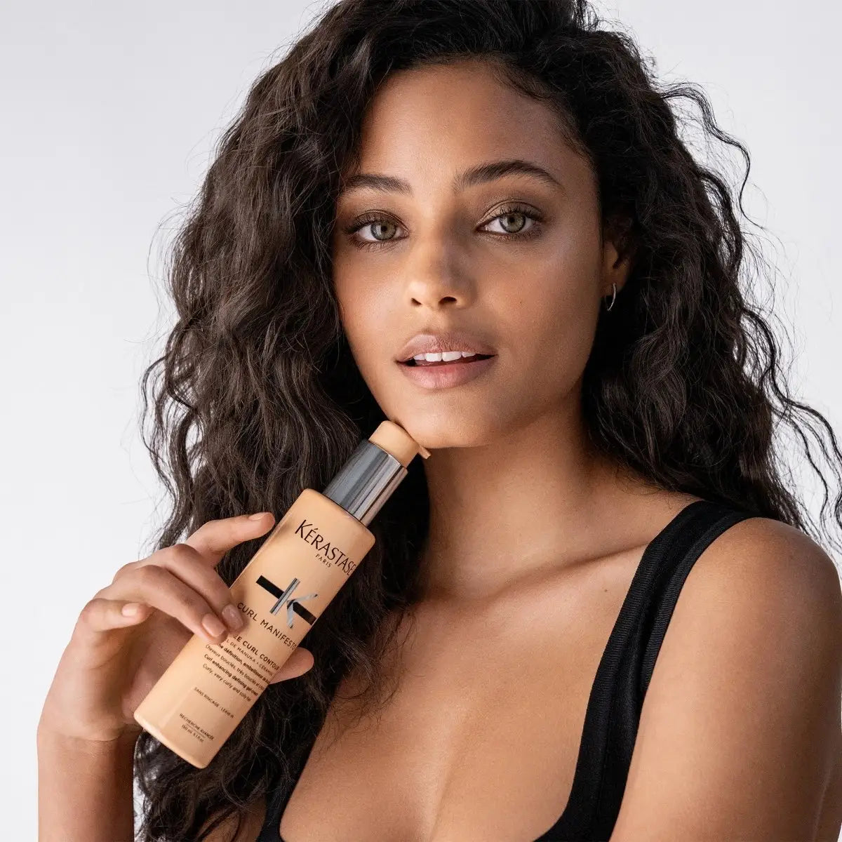 Tan bottle of Curl Manifesto Kerastase hair product for curly hair care