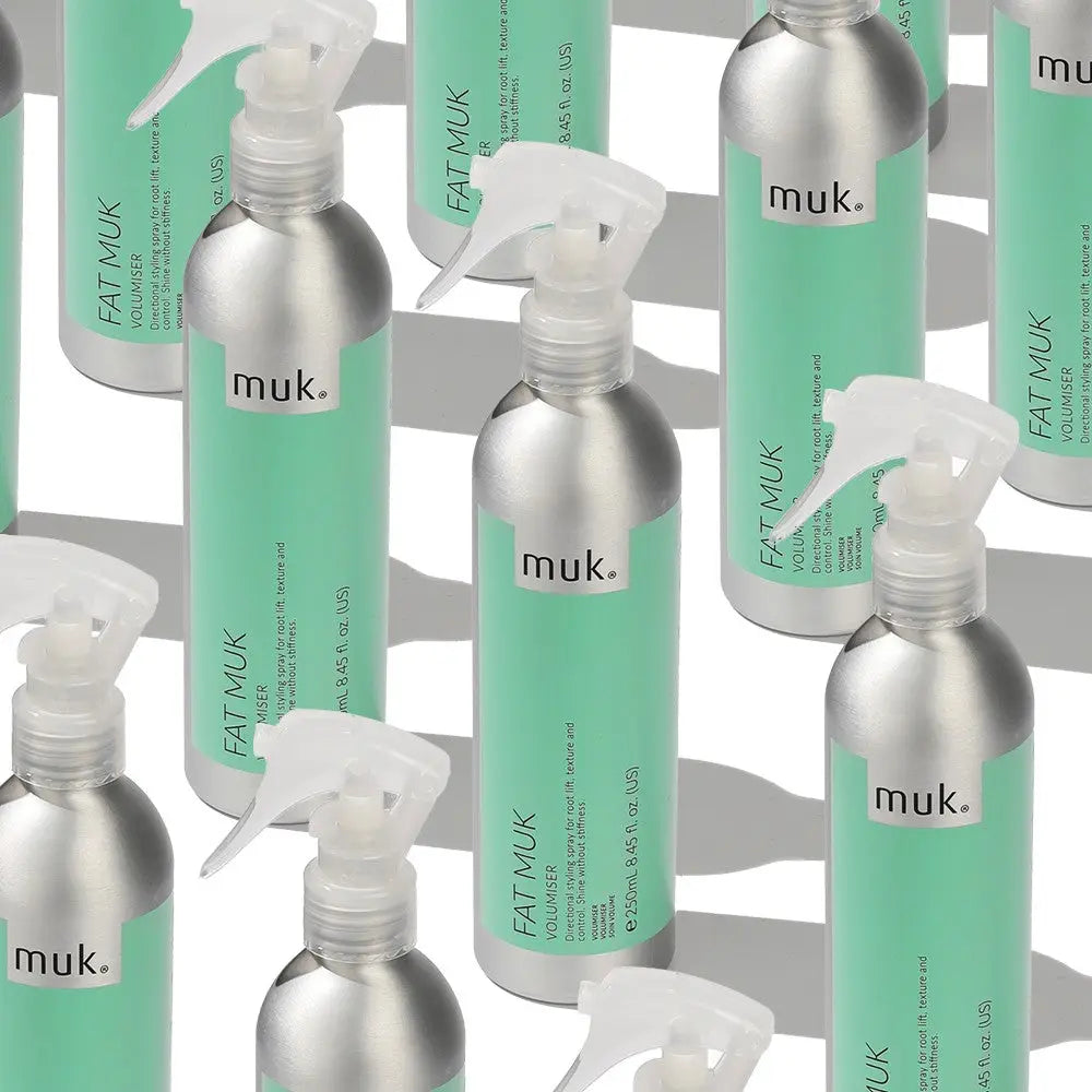 Multiple silver and mint green Fat Muk Volumizing Hair Care bottles for fullness and body