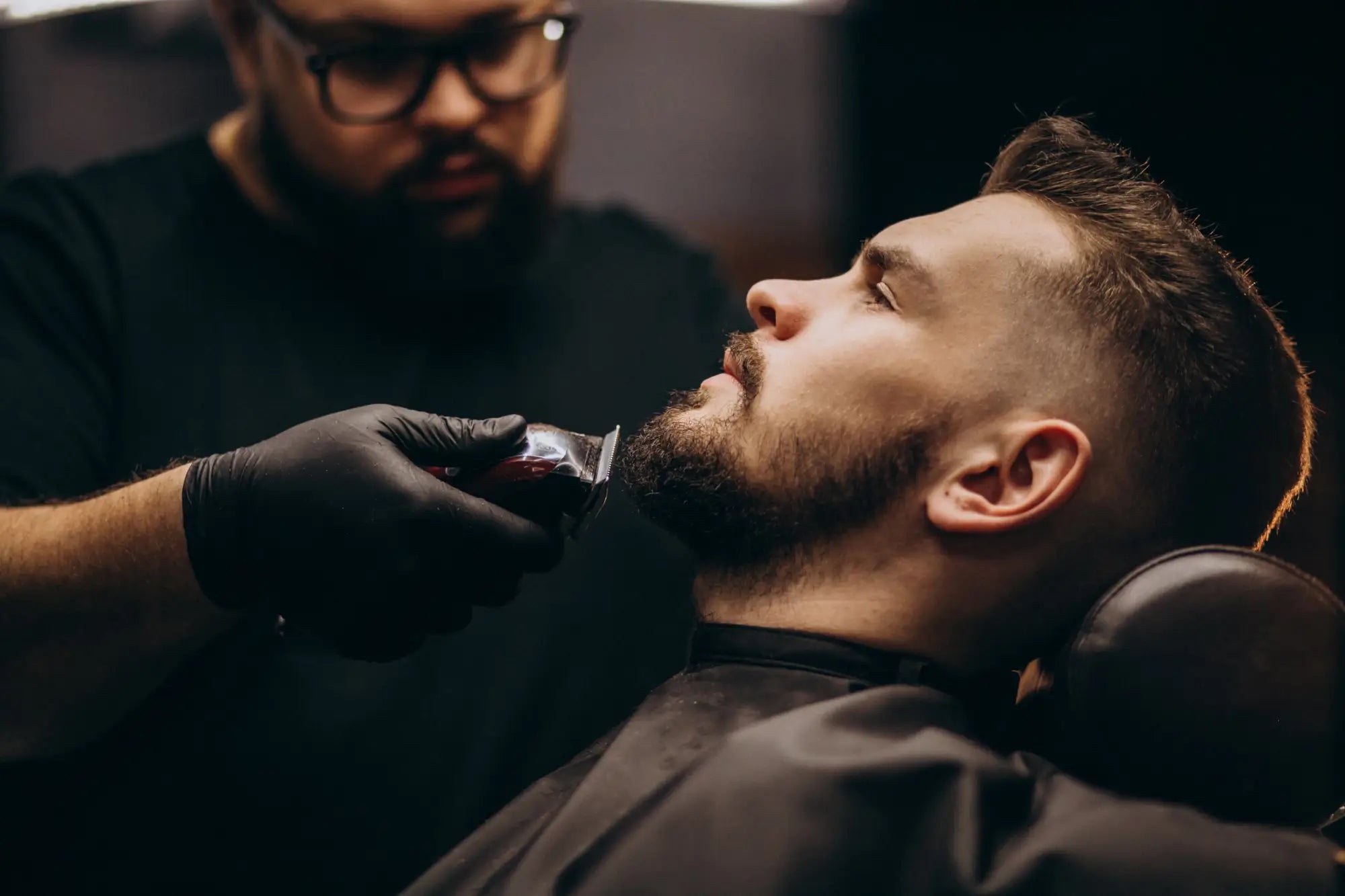 Man getting beard trimmed by barber in ’Gents Hair’; Paul Mitchell gents collection featured.