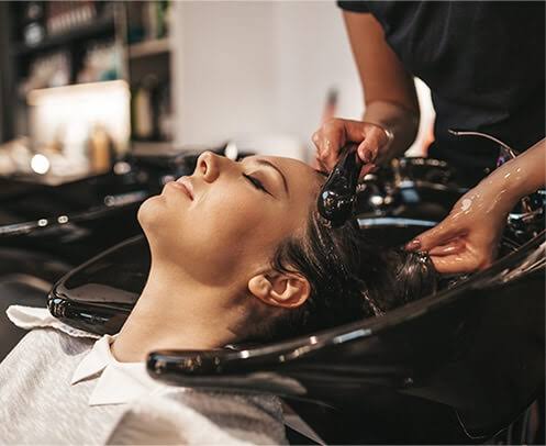 Woman enjoying Matrix Total Results hair wash at the Treatment Collection salon.