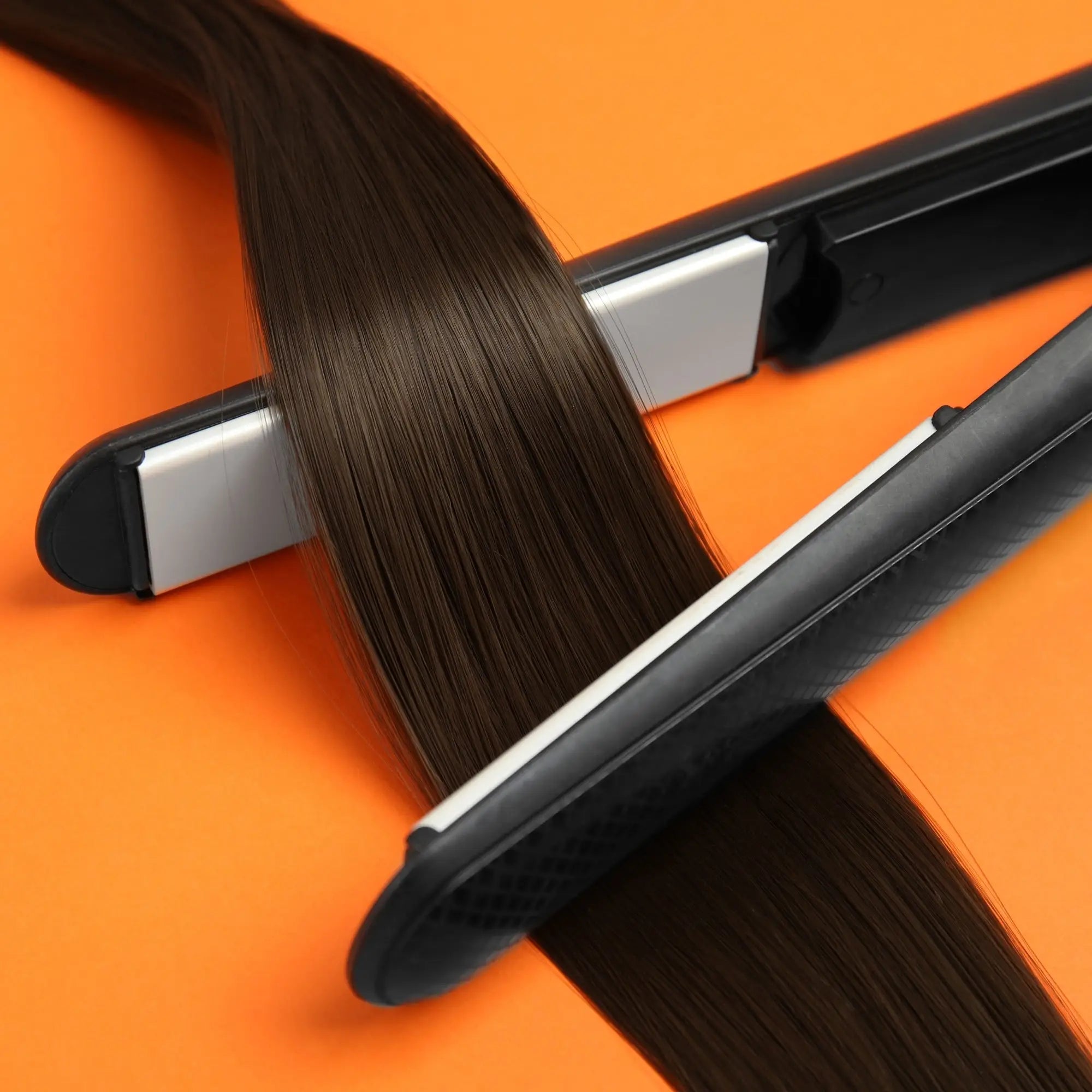 Hair straightener with dark brown hair demonstrating heat protection for hair care products.