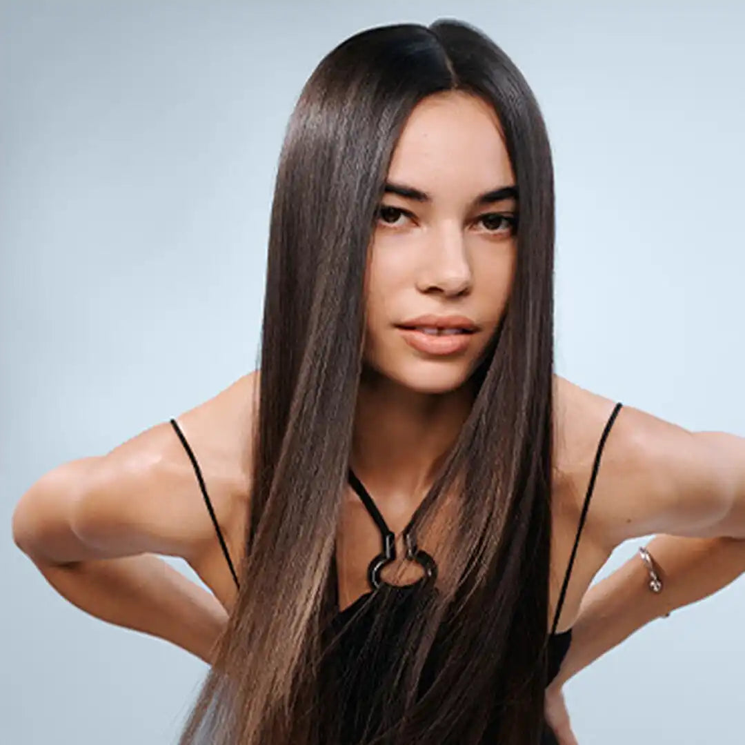 Long straight dark brown hair sleekly styled with a center part in New Haircare collection.