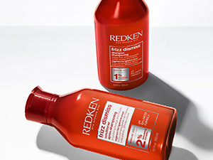 Redken shampoos: Red Redken bottles with white labels from the Redken Shampoo & Conditioner collection.