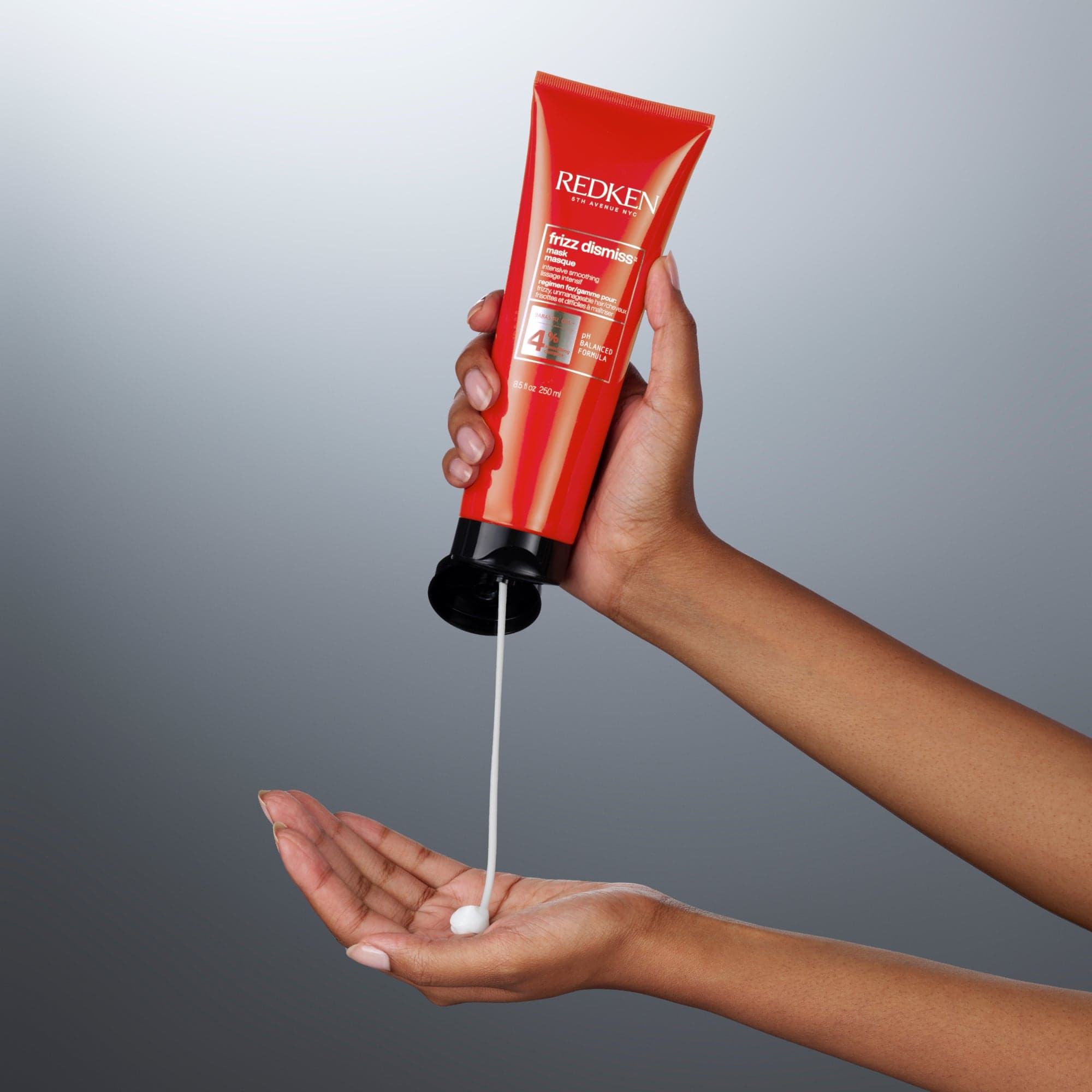 Redken Frizz Dismiss hair product being dispensed from a pump bottle in the collection