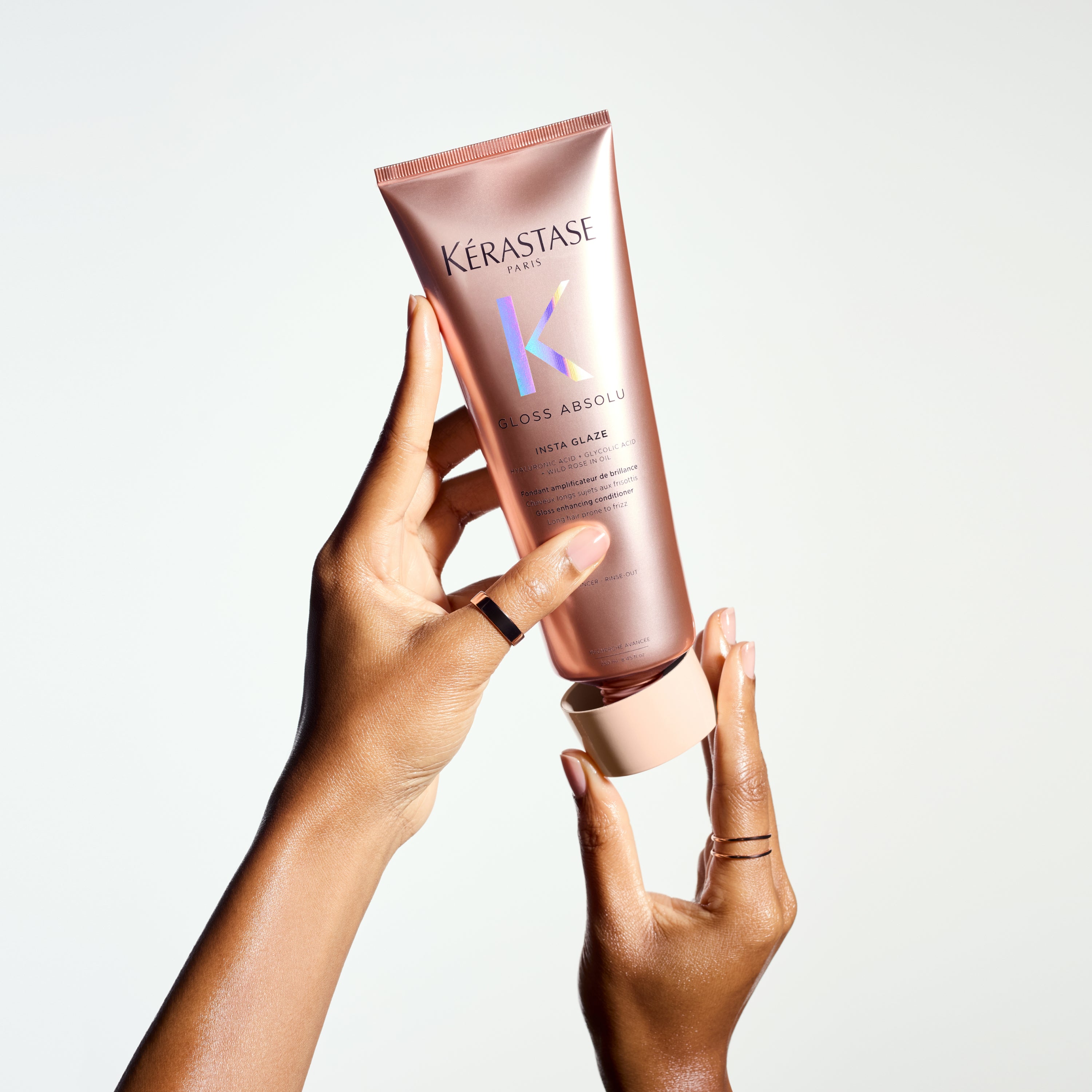 Kerastase Gloss Absolu Insta Glaze Conditioner: Hands Holding Shiny Hair Product, Anti-Frizz Treatment