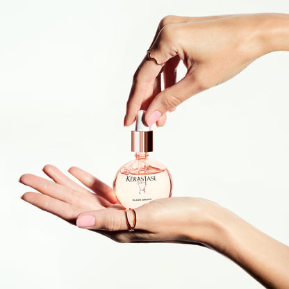KERASTASE Gloss Absolu Glaze Drops: Anti-Frizz Hair Oil for Shiny, Smooth Hair. Featured product in hand with ring.