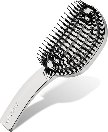 Oval-shaped hairbrush with alternating black and white bristles and a metallic handle.