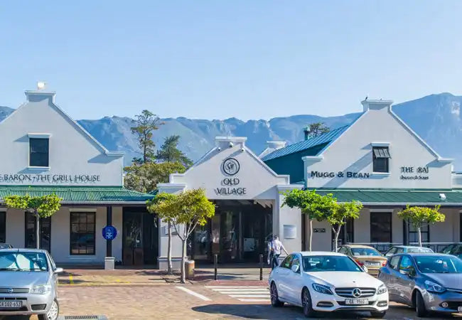 Cape Dutch-style commercial buildings with white walls and distinctive gabled roofs.