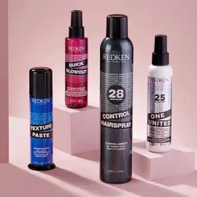 Collection of Redken hair styling products including sprays and paste.