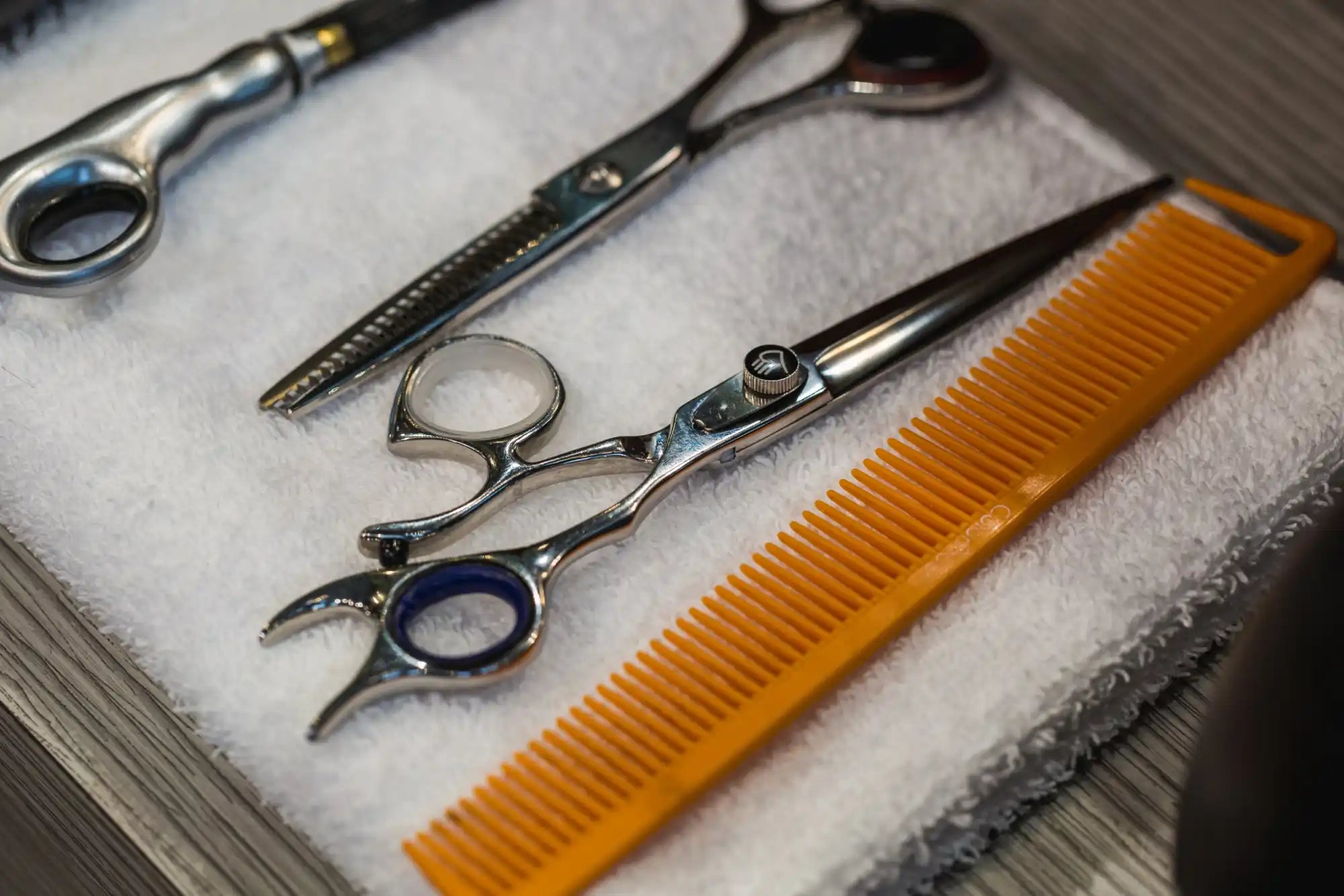 Collection of hairdressing tools including scissors, thinning shears, and a comb.