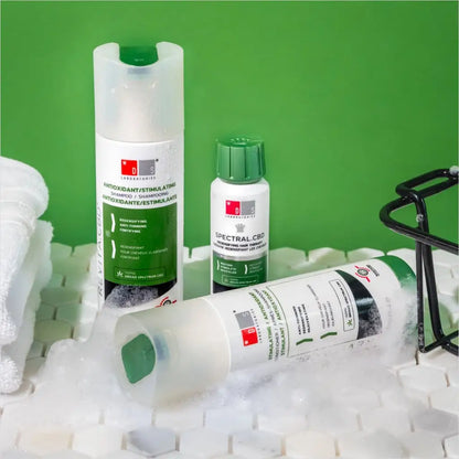 Skincare products from a medical or dermatological brand displayed on a green background.