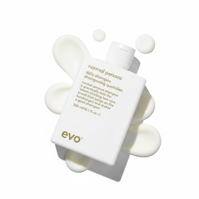 EVO Normal Persons Daily Shampoo white bottle with cream texture background for daily hair care