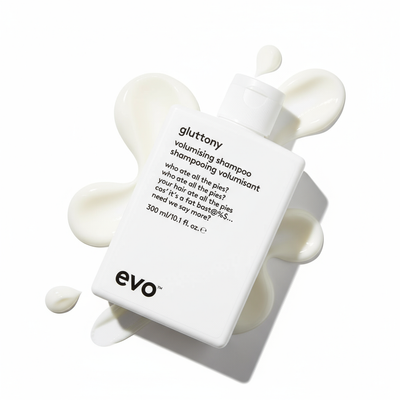 EVO Gluttony Volumising Shampoo bottle with white creamy shampoo swirls on white background
