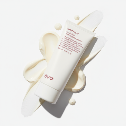 EVO Total Recoil Curl Definer tube on white background with creamy product texture swirls