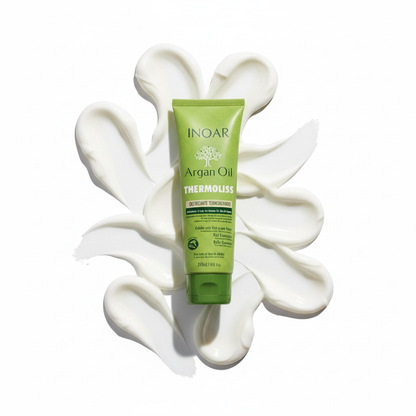 Green tube of Inoar Argan Oil Thermoliss Anti-Frizz Balm with cream spread on white background