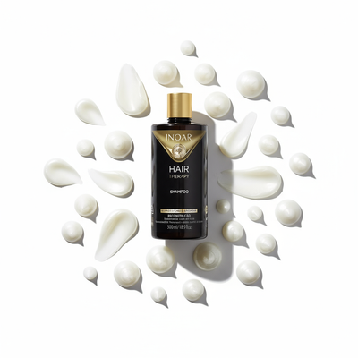 Inoar Hair Therapy Shampoo bottle surrounded by creamy white lotion drops on white background
