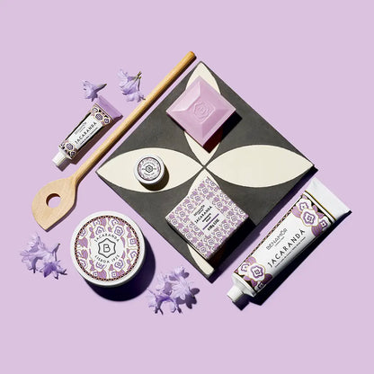 Flat lay of jacarandá body lotion gift set with aloe vera in purple and white tones