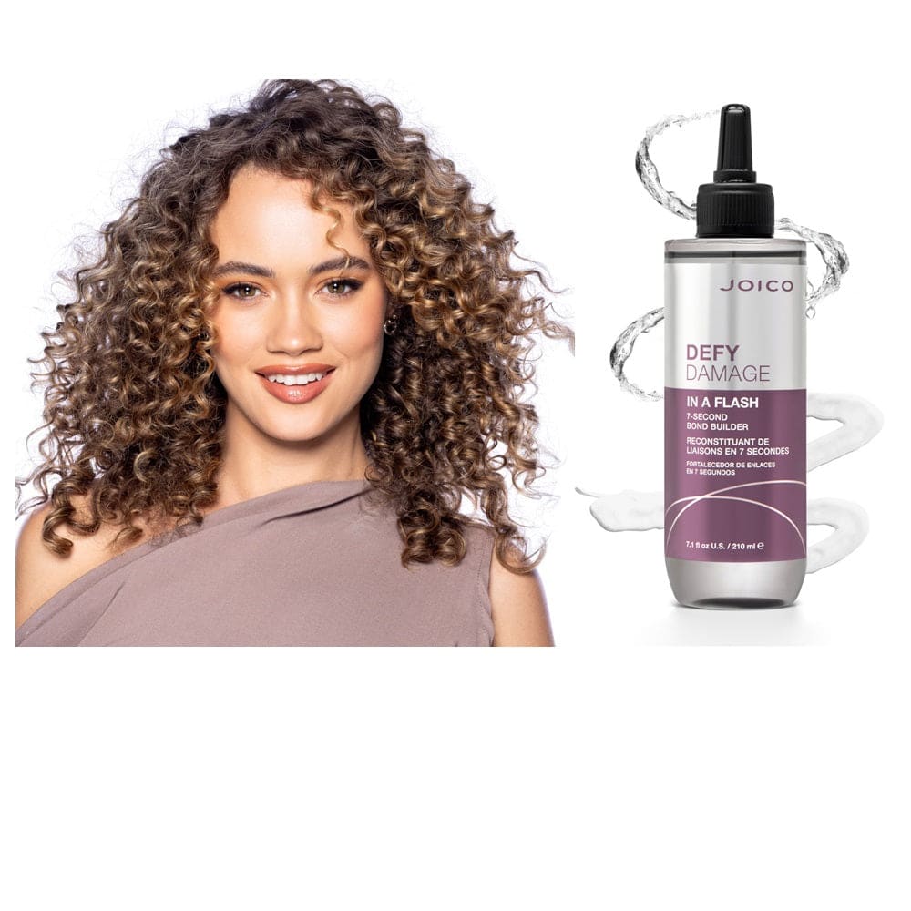 Woman with voluminous curly brown hair smiling using Joico Defy Damage hair products