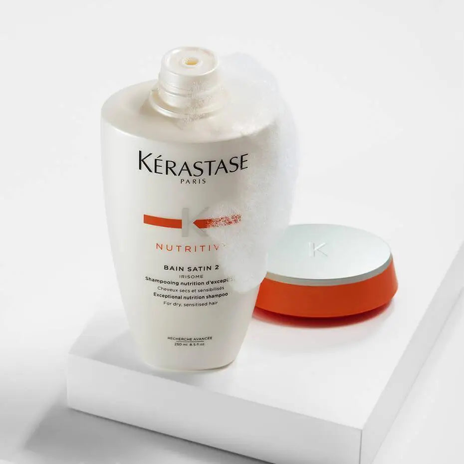 Bottle of Kérastase Nutritive Irisome Bain Satin 2 Shampoo with product container - 250ml