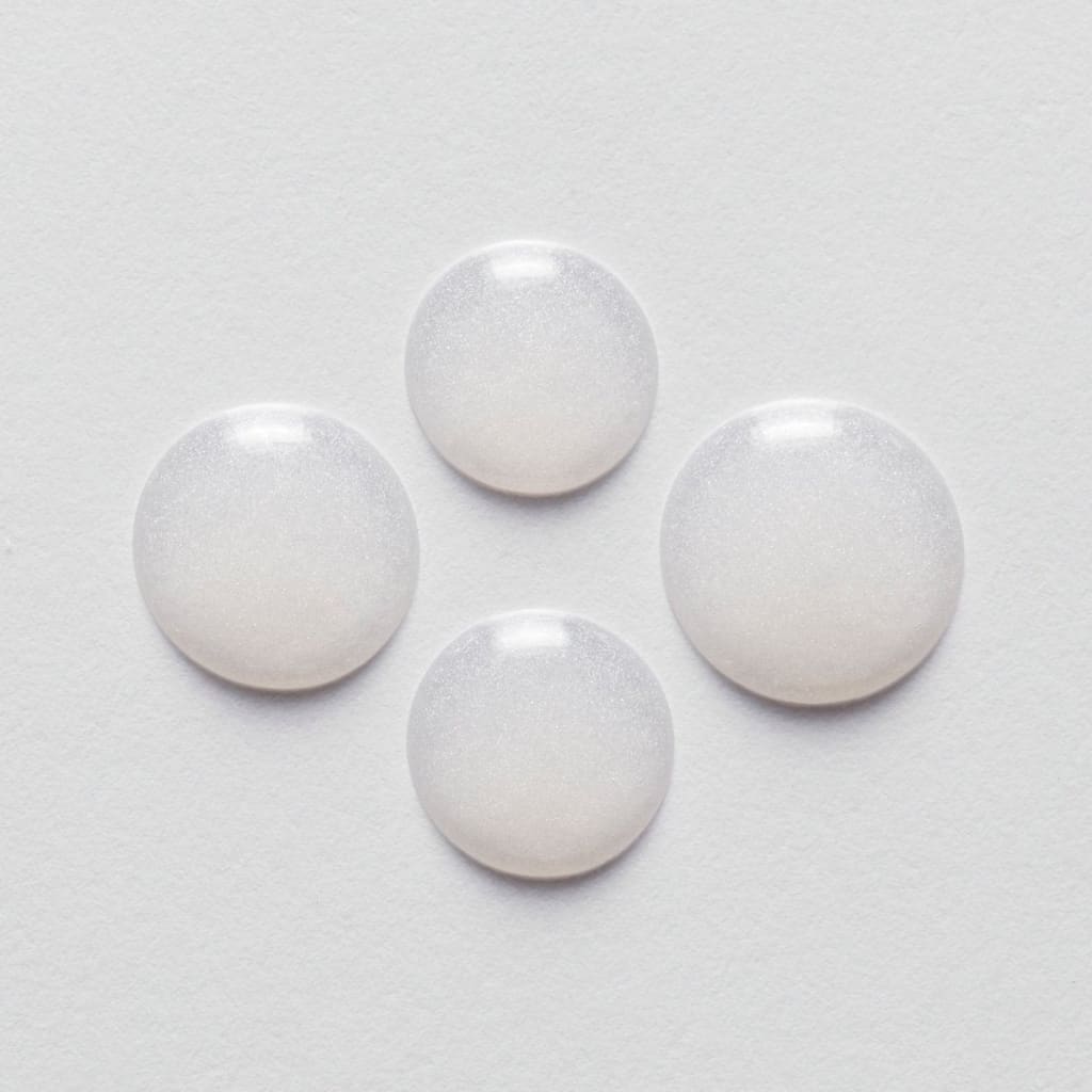 Four white pills arranged in a diamond shape for Kerastase Resistance Serum Extentioniste 50ml