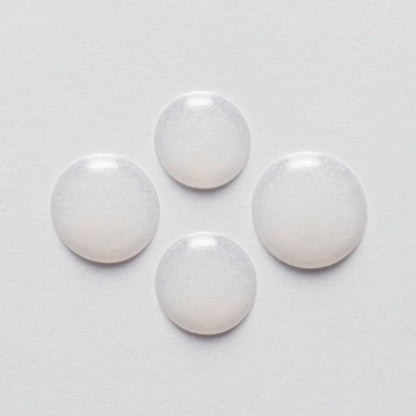 Four white pills arranged in a diamond shape for Kerastase Resistance Serum Extentioniste 50ml