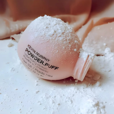Kevin Murphy Powder.Puff volumizing powder. Texture powder spilled around the product bottle. Hair styling product.