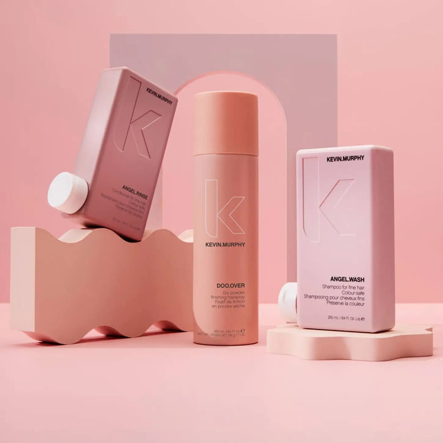 Pink cylindrical cosmetic bottle and boxes from Kevin Murphy Vibing Volume Holiday set