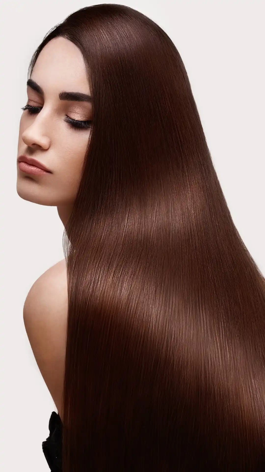 Long, straight, shiny brown hair cascading down a person’s back and shoulder.