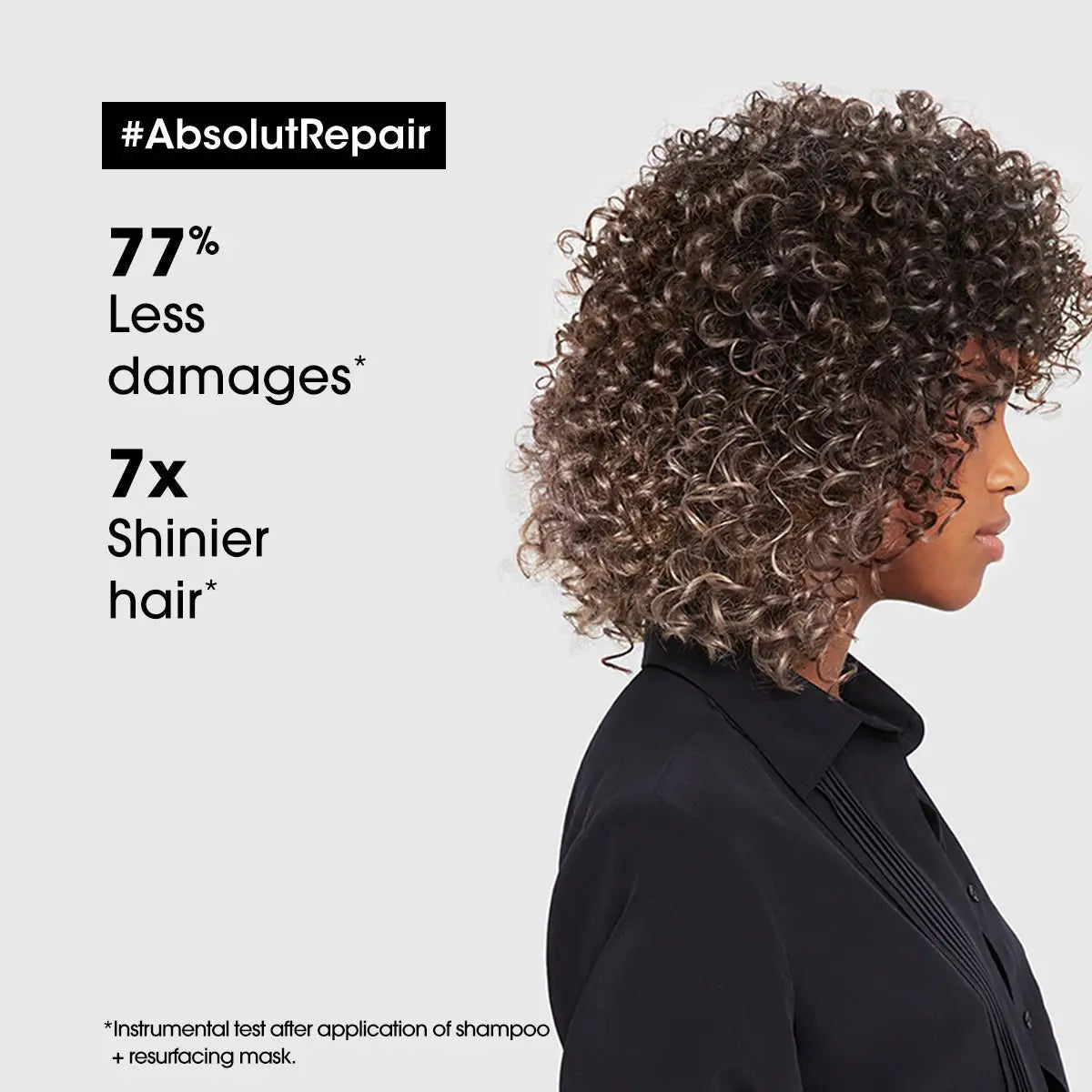 A person with voluminous curly hair wearing a black top; Loreal Absolut Repair Conditioner 200ml