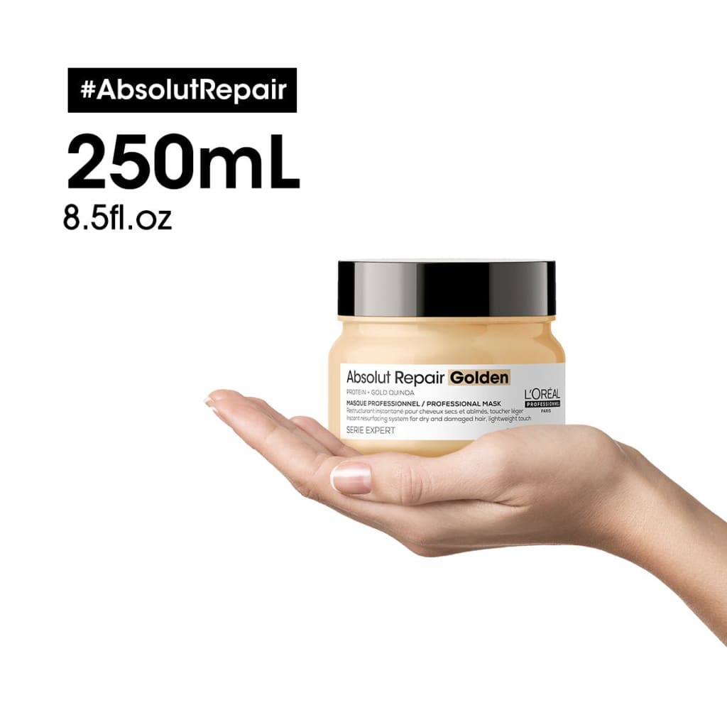 A jar of L’Oréal Absolut Repair Golden hair mask held in a hand - l’oréal professionnel