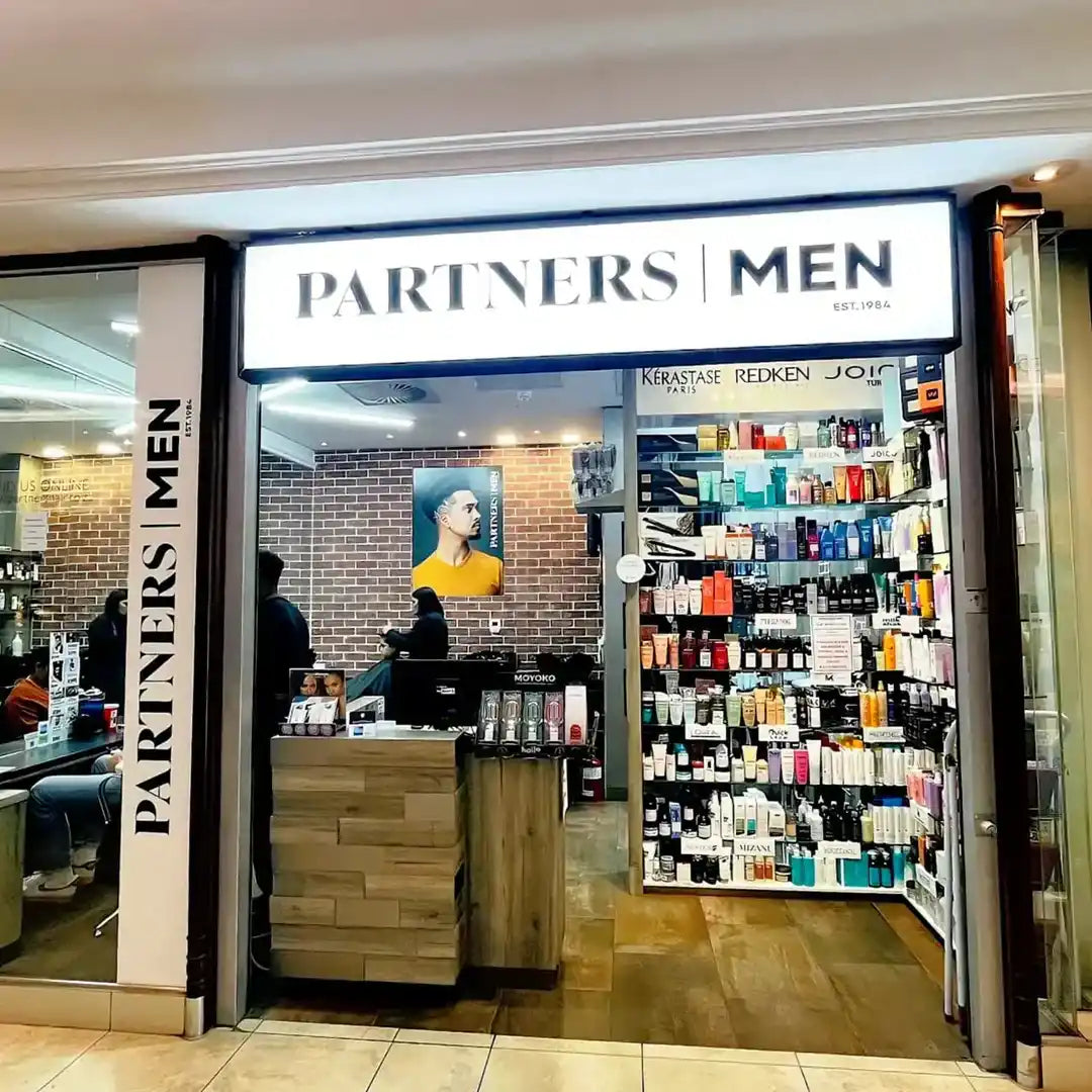 Men’s hair salon and grooming products store with ’Partners Men’ signage.