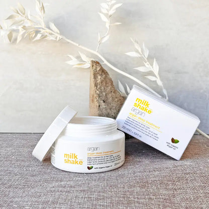 Milkshake Argan Deep Treatment for hair in an open white jar with product box on gray surface