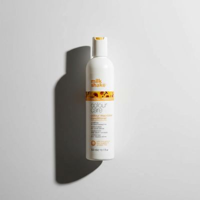 Milkshake color-treated hair conditioner in white bottle with yellow accents for color care