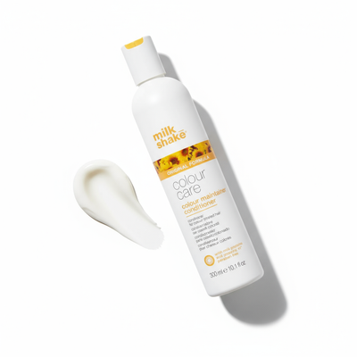 Milkshake color-treated hair conditioner bottle with cream texture on white background