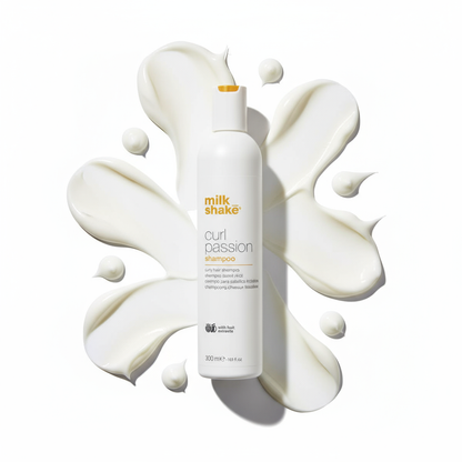 Milkshake Curl Passion Shampoo bottle surrounded by creamy white swirls of shampoo cream