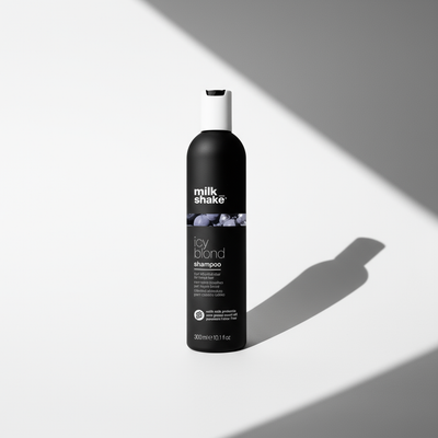 Milkshake Icy Blonde Shampoo black bottle with white cap on light background with shadow