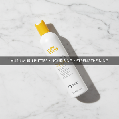 Milkshake integrity conditioner bottle with nourishing Murumuru Butter on white marble surface