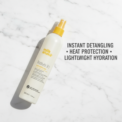 Milkshake leave in conditioner 350ml bottle with yellow spray cap on white marble background