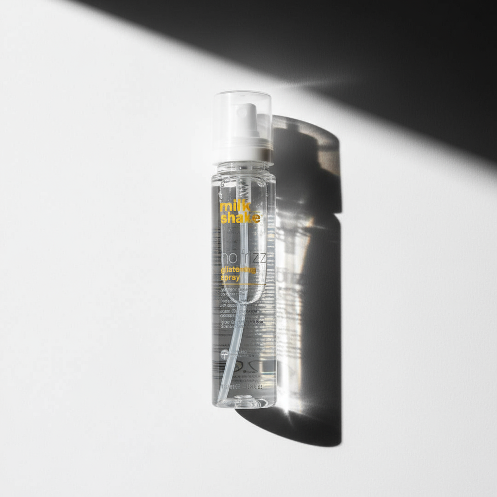 Milkshake no frizz glistening spray clear styling aid bottle with white spray cap casting shadow