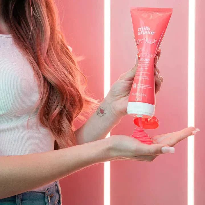 A woman holding a tube of Milkshake Pink Lemonade Shampoo 300ml for lightened hair