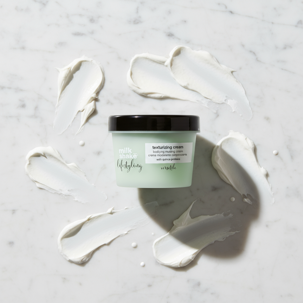 Milkshake Texturizing Cream 100ml styling aid in a green jar with cream smears on marble surface