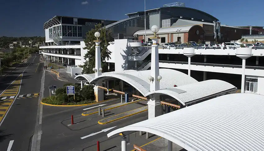 Modern airport terminal building with curved white architectural features and multiple levels.