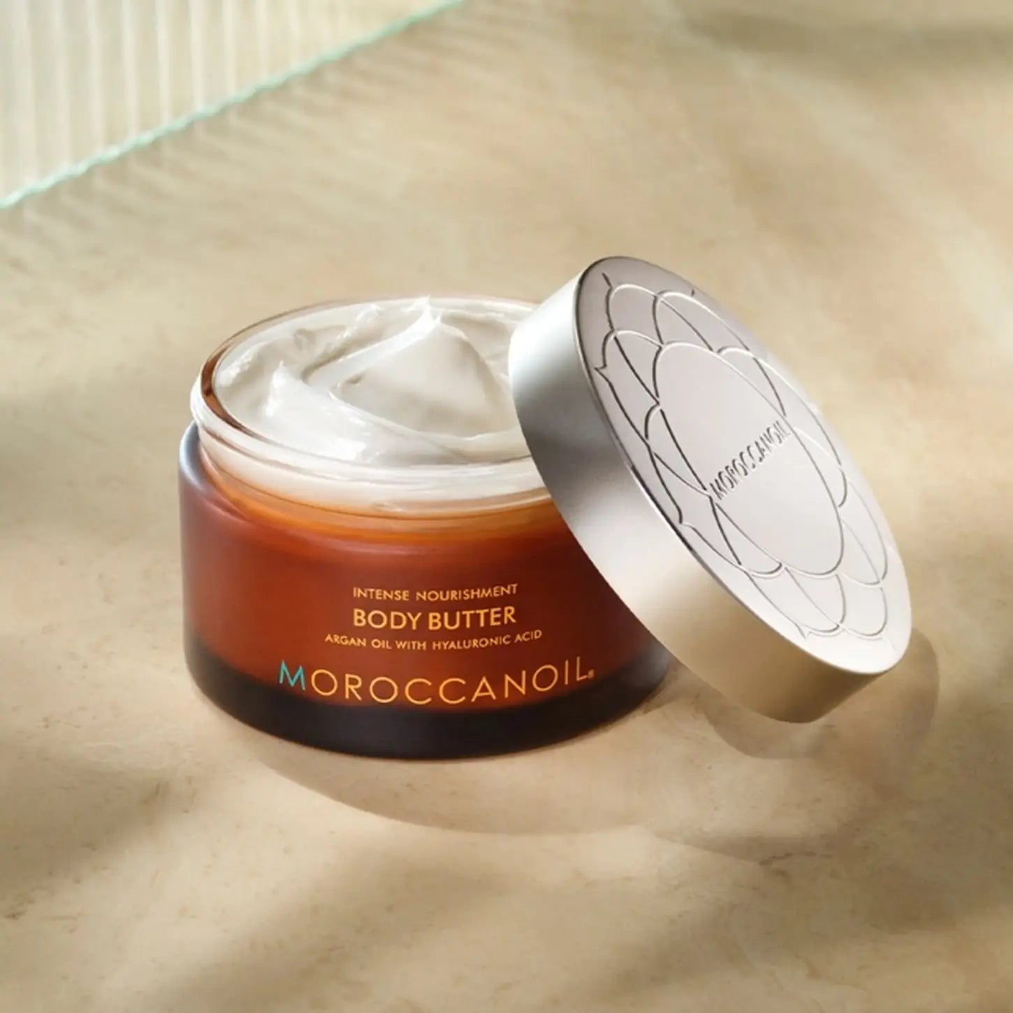 Open jar of Moroccanoil Body Butter 200ml, perfect for dehydrated skin hydration