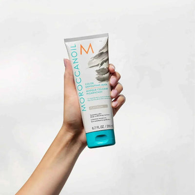 Moroccanoil Color Depositing Mask Platinum hair treatment in a 6.7 fl oz tube held by hand