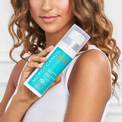 Person with wavy hair holding Moroccanoil Curl Defining Cream 250ml for curl memory factor