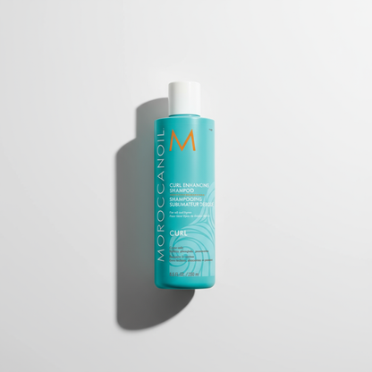 Moroccanoil curl enhancing shampoo bottle in turquoise with white cap on white background
