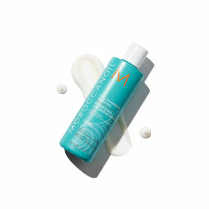 Moroccanoil curl enhancing shampoo bottle with white shampoo product swatches on white background