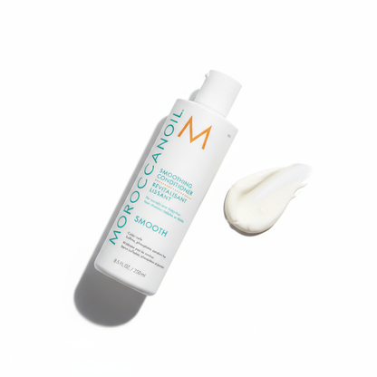 Moroccanoil smoothing conditioner bottle with creamy conditioner swatch on white background