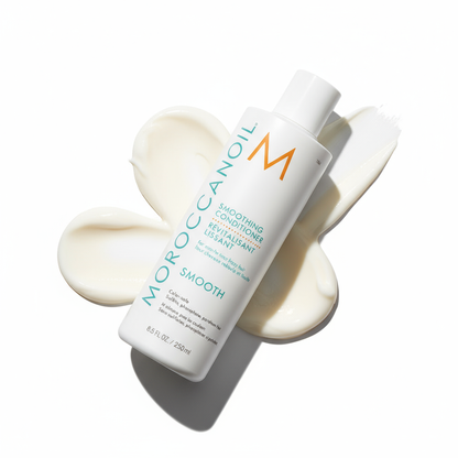 Moroccanoil smoothing conditioner bottle with cream texture on white background