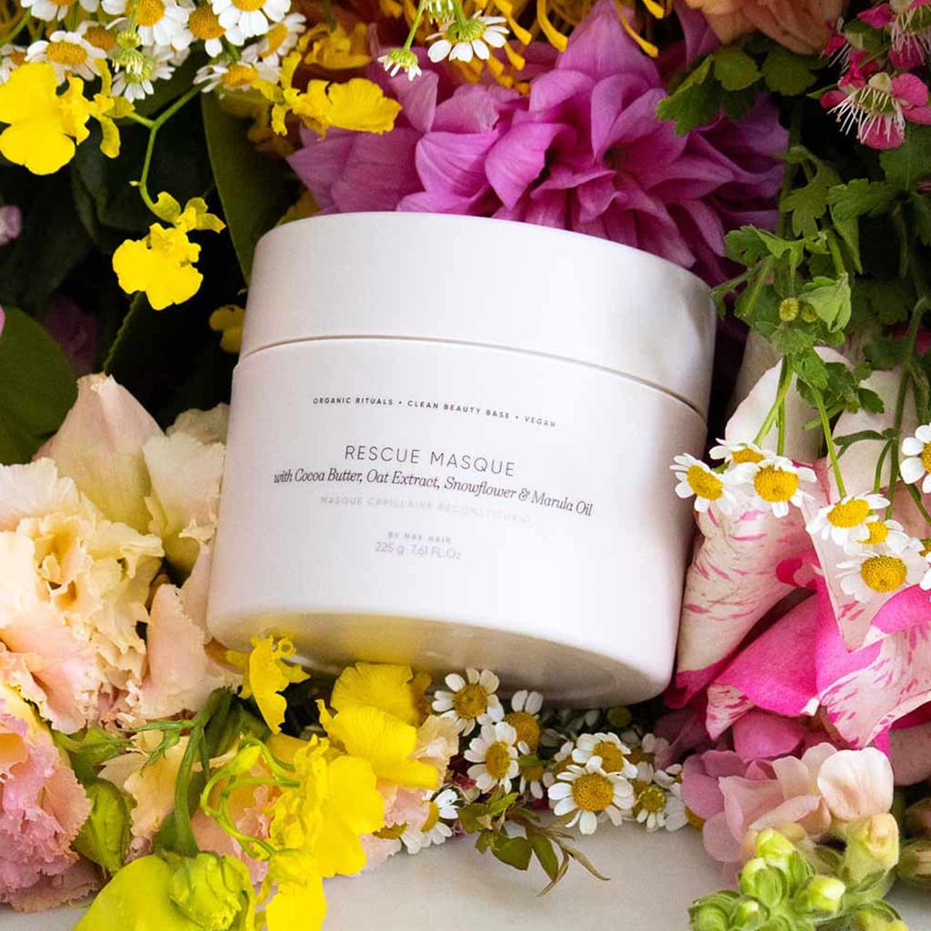 White ORI Lab Rescue Masque 225ml jar surrounded by colorful flowers for skincare